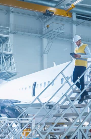 Worker using tablet in airplane warehouse