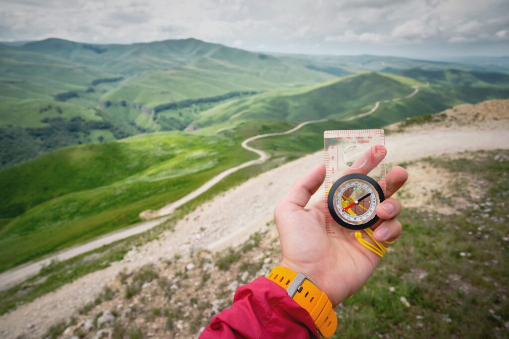 Person holding the compass on a mountain